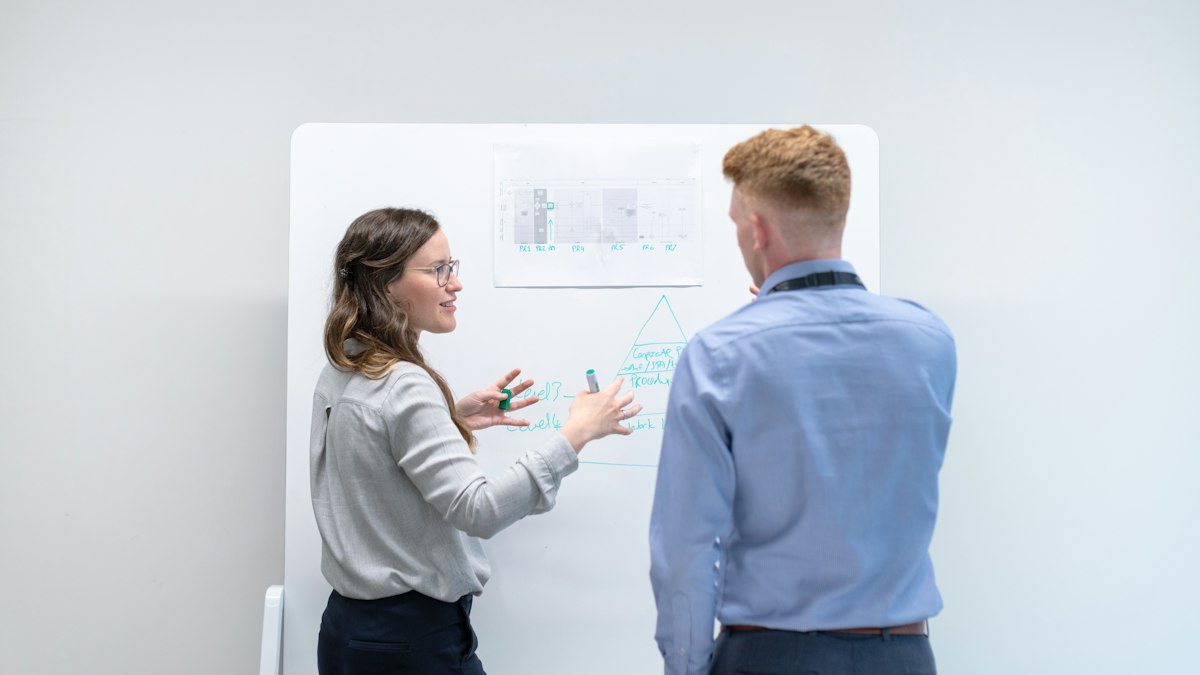 Two people discussing ideas at a whiteboard