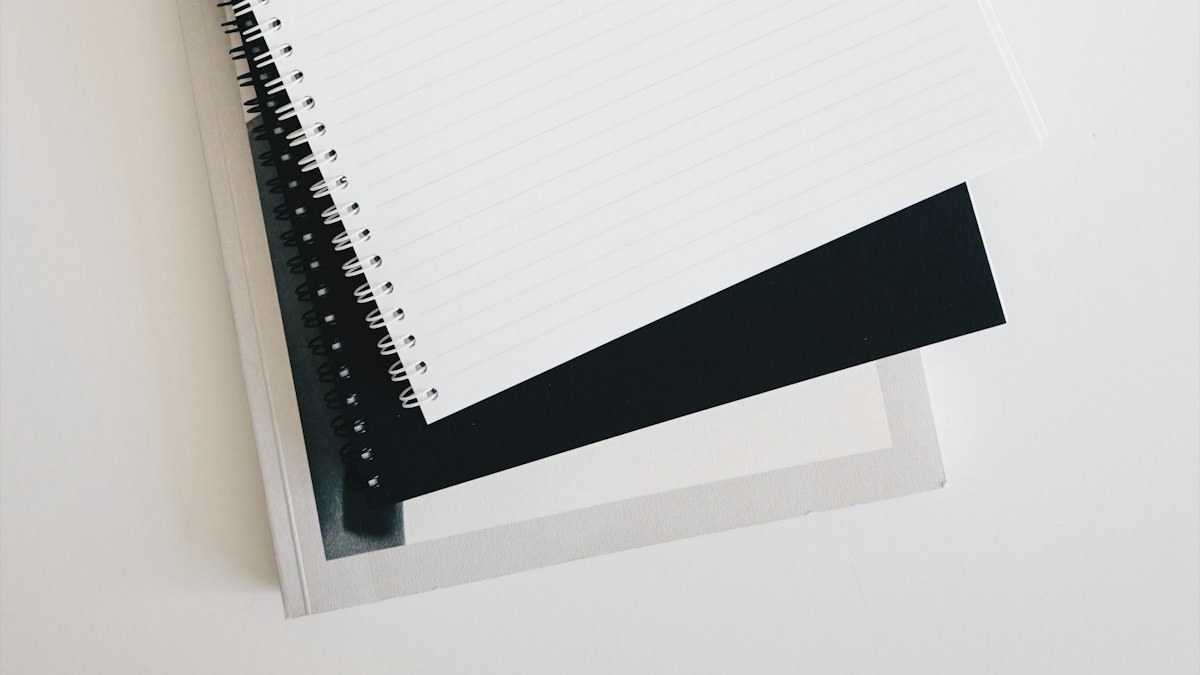 A notebook and pen next to a keyboard