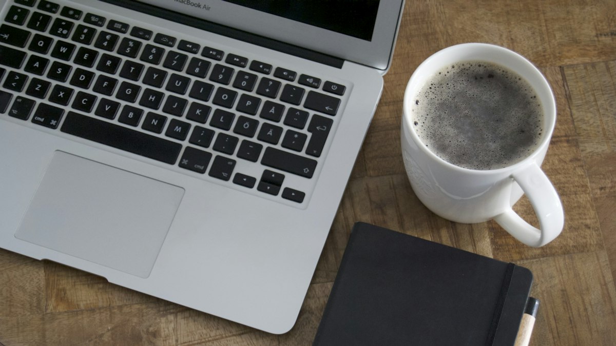 A laptop and mug on a wooden table