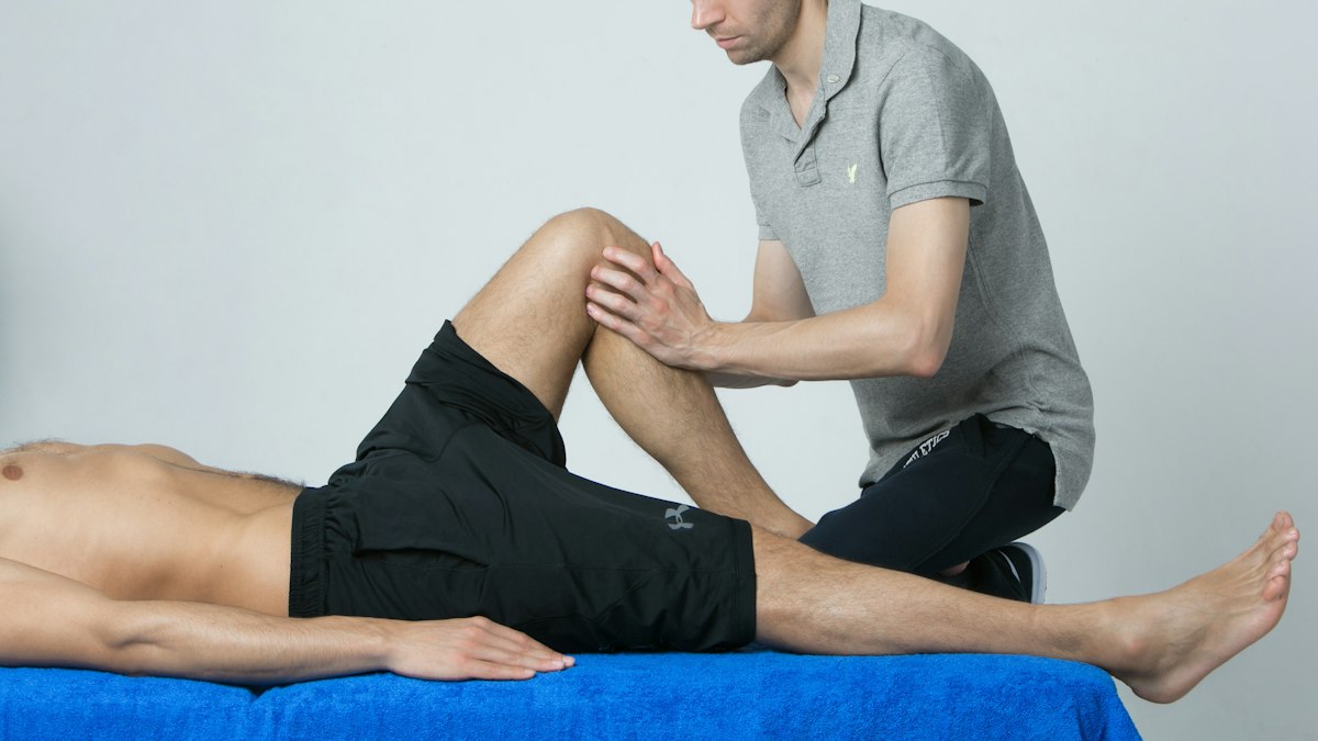A practitioner examining a patient's leg