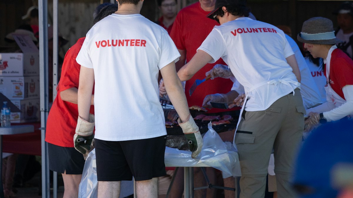Volunteers organising donated items under a tent