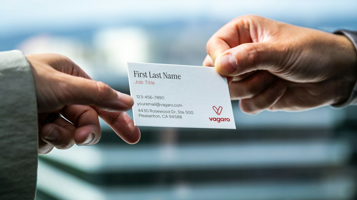 Two hands exchanging a business card