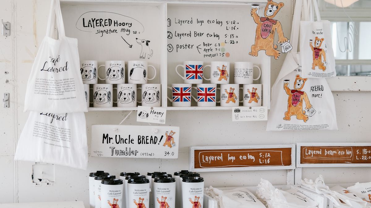 Branded mugs, tote bags and tumblers on shelves