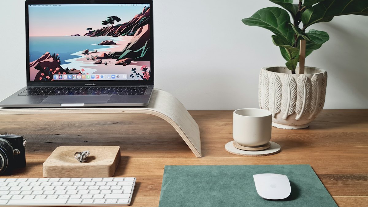 A laptop on a wooden desk, ready for online registration